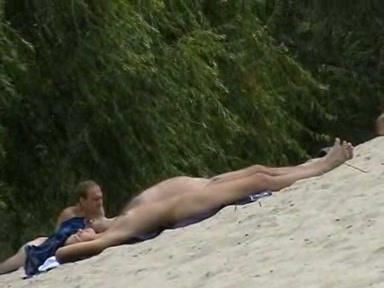 Nude couple chilling on the beach